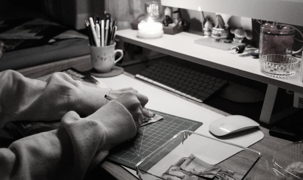 image shows a pair of hands cutting paper